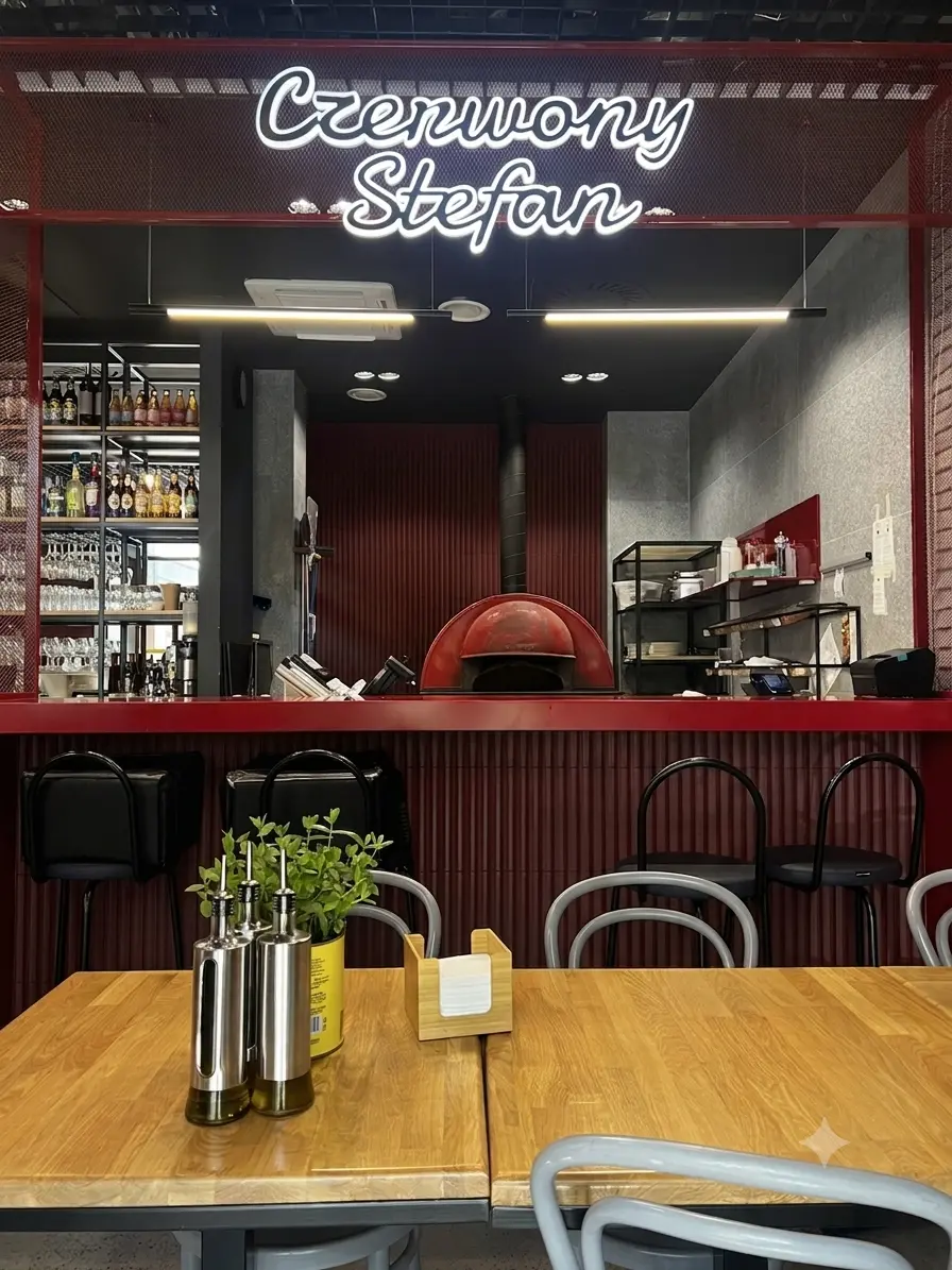 Wnętrze Pizzerii Czerwony Stefan na Woli — lada, piec do pizzy i neon z nazwą restauracji